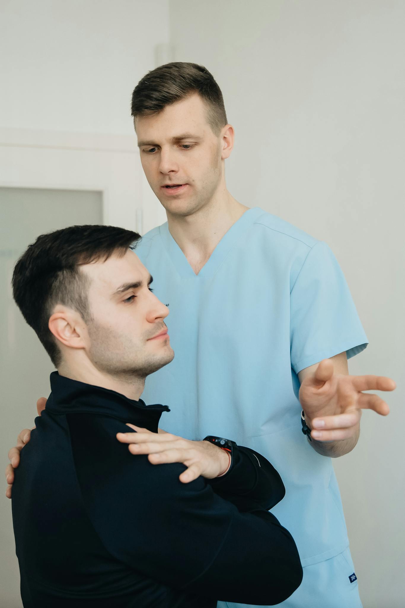 A physiotherapist assists a patient during a therapy session indoors.